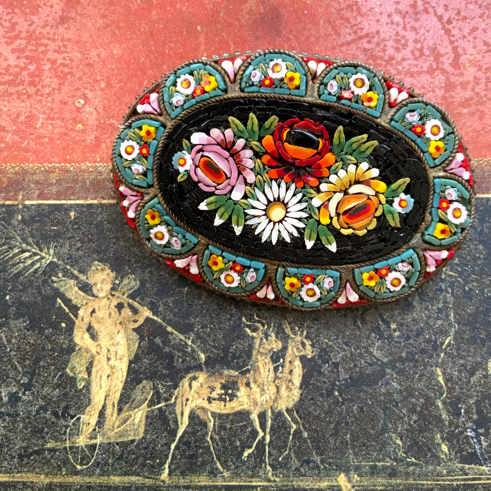 A vibrant and colorful oval micro mosaic brooch featuring a striking floral design.鮮やかでカラフルなお花のマイクロモザイク のオーバル型ブローチ。