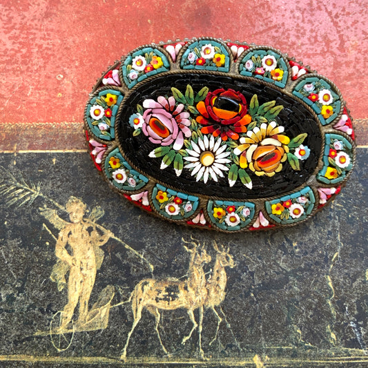 A vibrant and colorful oval micro mosaic brooch featuring a striking floral design.鮮やかでカラフルなお花のマイクロモザイク のオーバル型ブローチ。