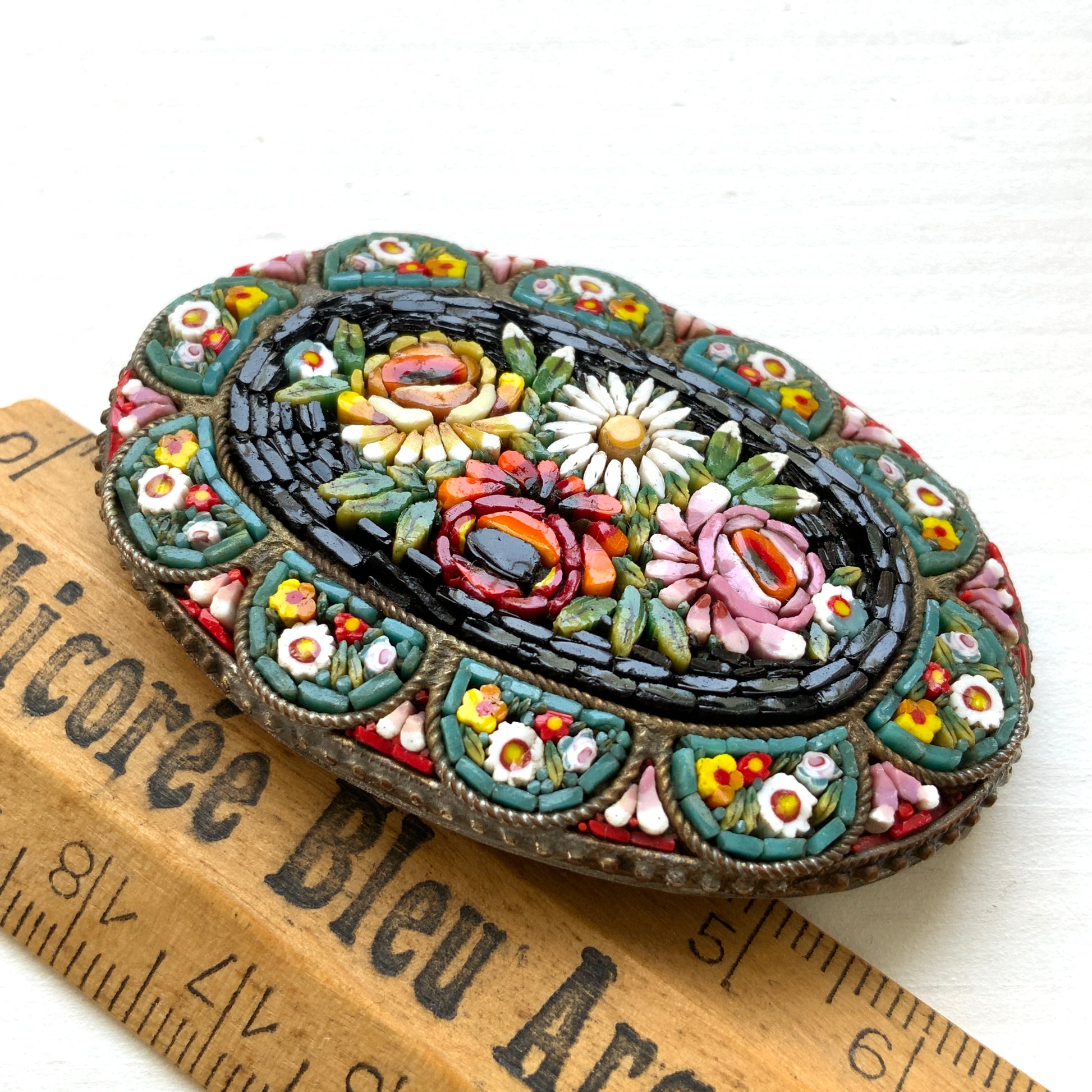 A vibrant and colorful oval micro mosaic brooch featuring a striking floral design.鮮やかでカラフルなお花のマイクロモザイク のオーバル型ブローチ。