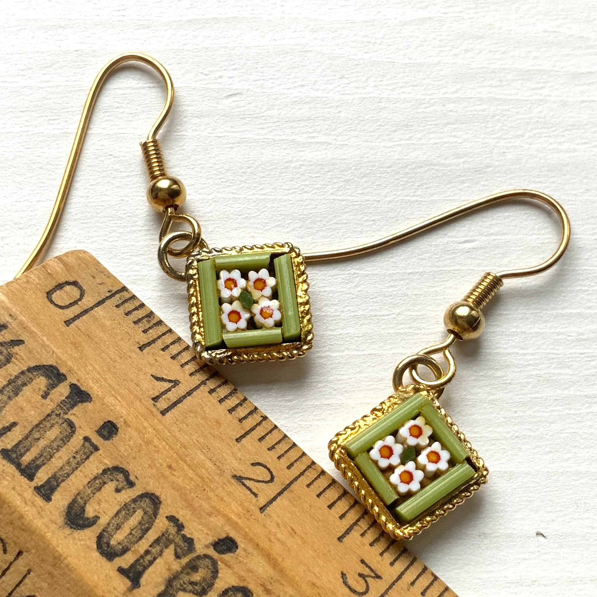These charming micro mosaic earrings feature a petite diamond shape filled with daisy-like tiny flowers.  小さなダイヤモンド型にデイジー のような小さなお花がギュッと詰め込まれたかわいらしいマイクロモザイク のピアス。