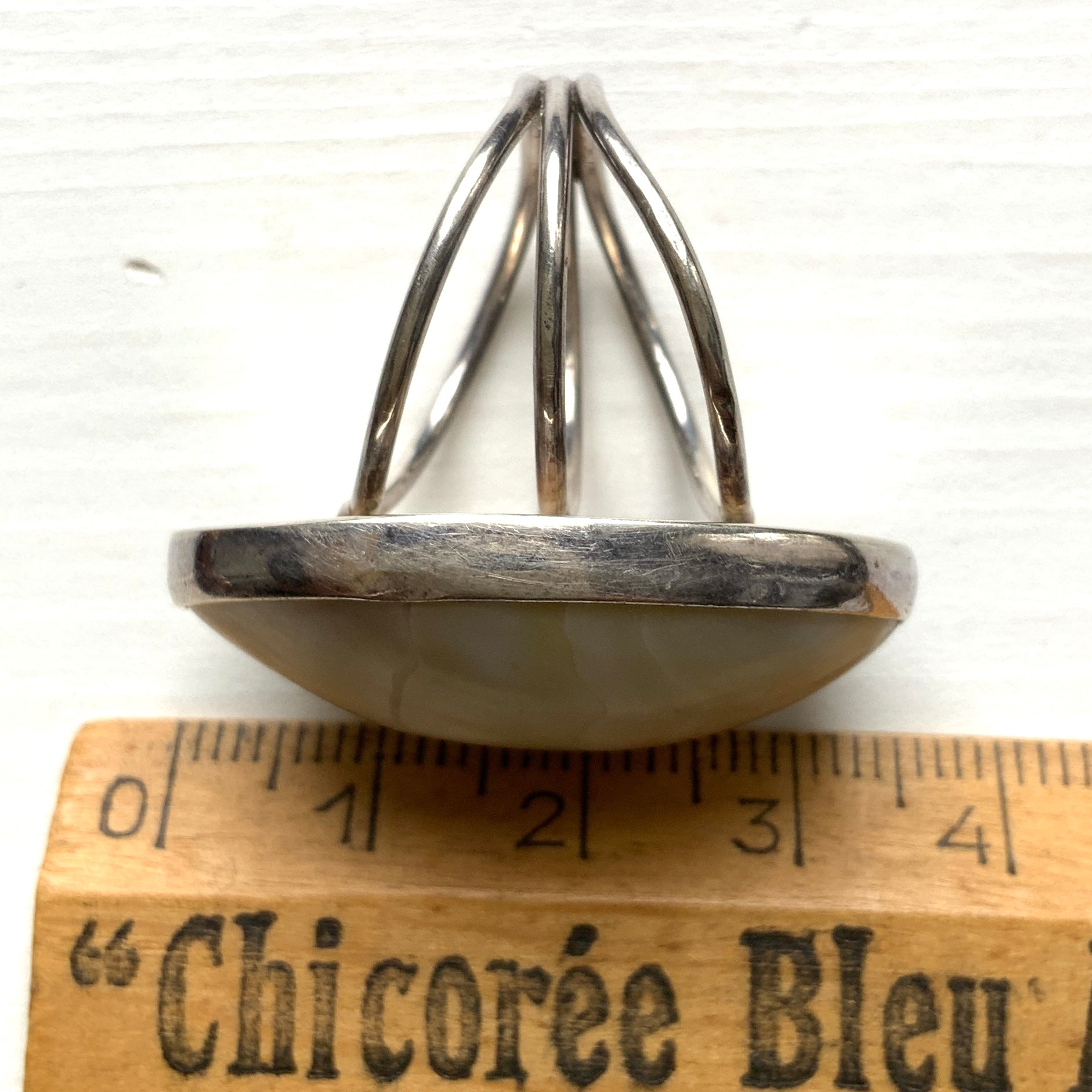 A silver ring featuring an oval domed piece of ivory-colored mother of pearl. アイボリーカラーのマザーオブパールをあしらった、オーバル型ドームのシルバーリング。