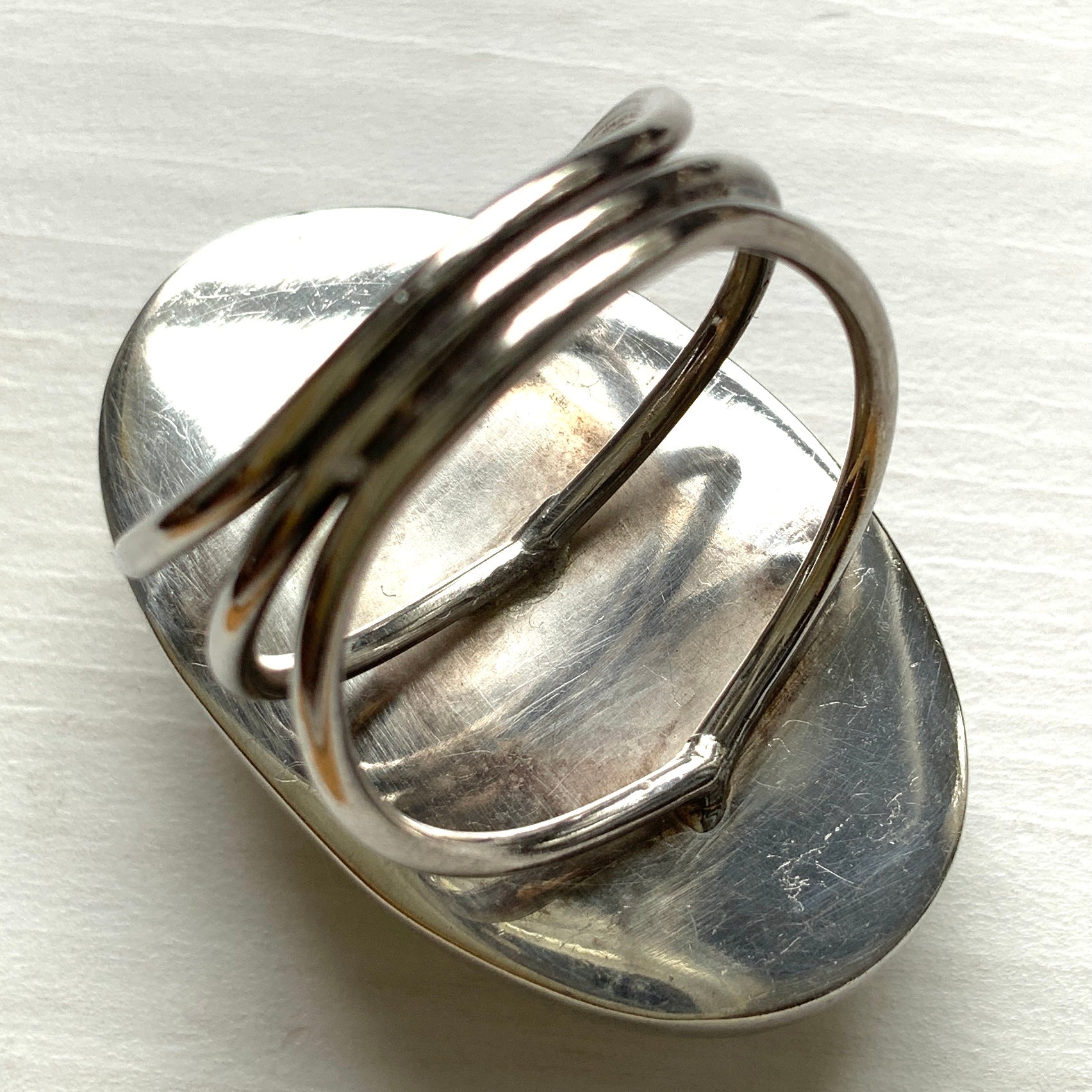 A silver ring featuring an oval domed piece of ivory-colored mother of pearl. アイボリーカラーのマザーオブパールをあしらった、オーバル型ドームのシルバーリング。