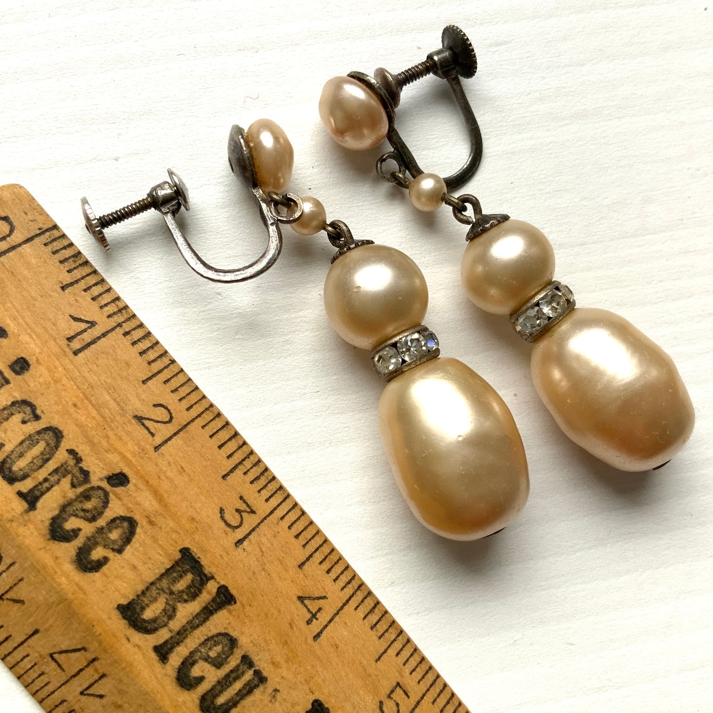 Cream-coloured glass pearls dangle from these screw-back earrings. クリームカラーのグラスパールがゆれるスクリューイヤリング。