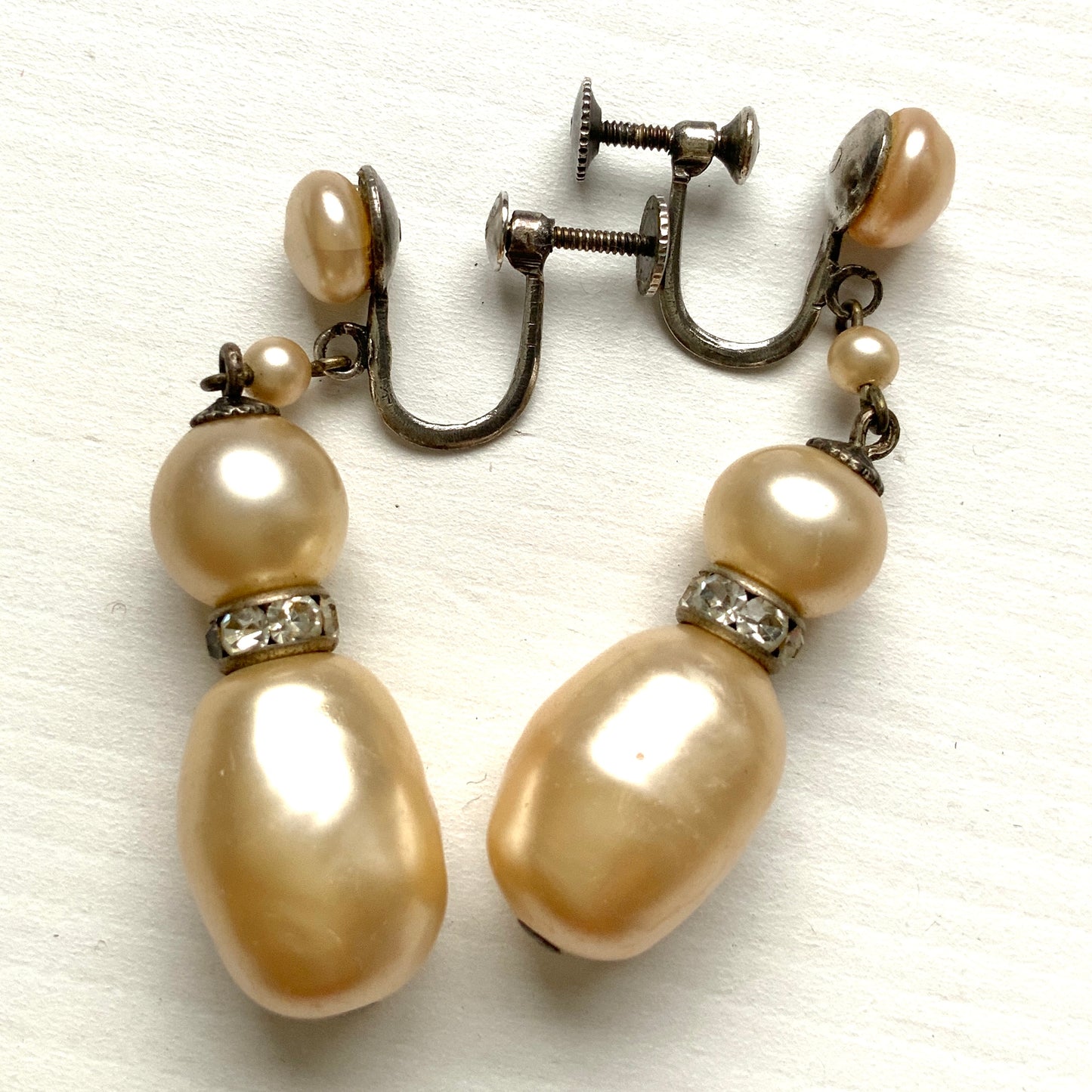 Cream-coloured glass pearls dangle from these screw-back earrings. クリームカラーのグラスパールがゆれるスクリューイヤリング。