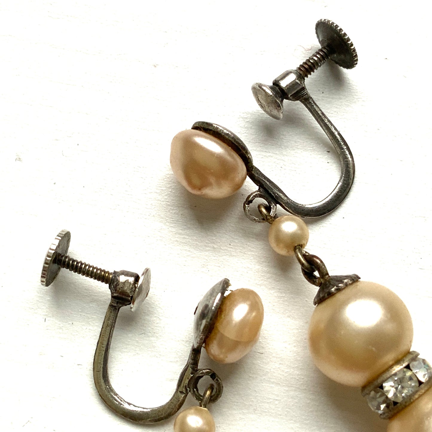 Cream-coloured glass pearls dangle from these screw-back earrings. クリームカラーのグラスパールがゆれるスクリューイヤリング。