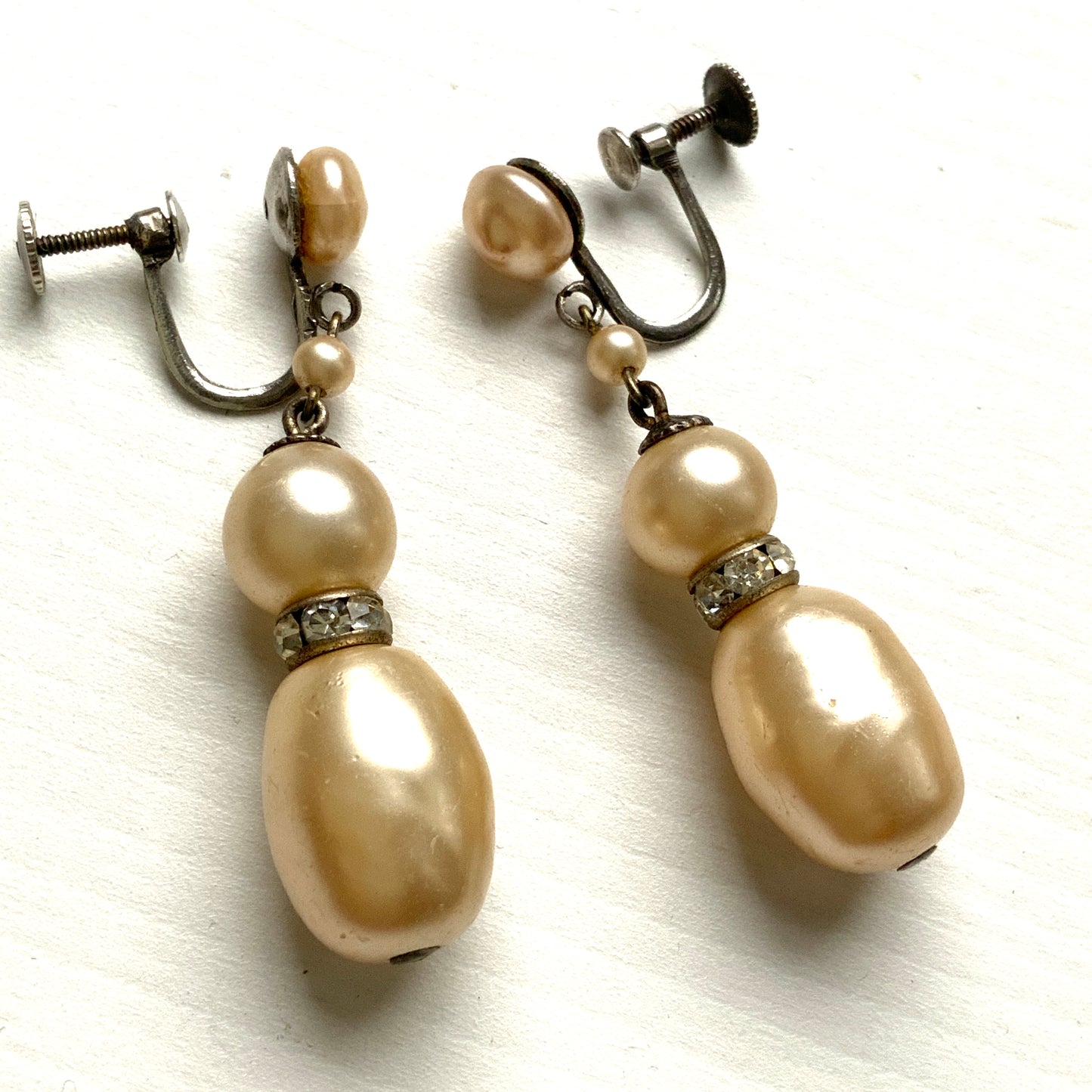 Cream-coloured glass pearls dangle from these screw-back earrings. クリームカラーのグラスパールがゆれるスクリューイヤリング。