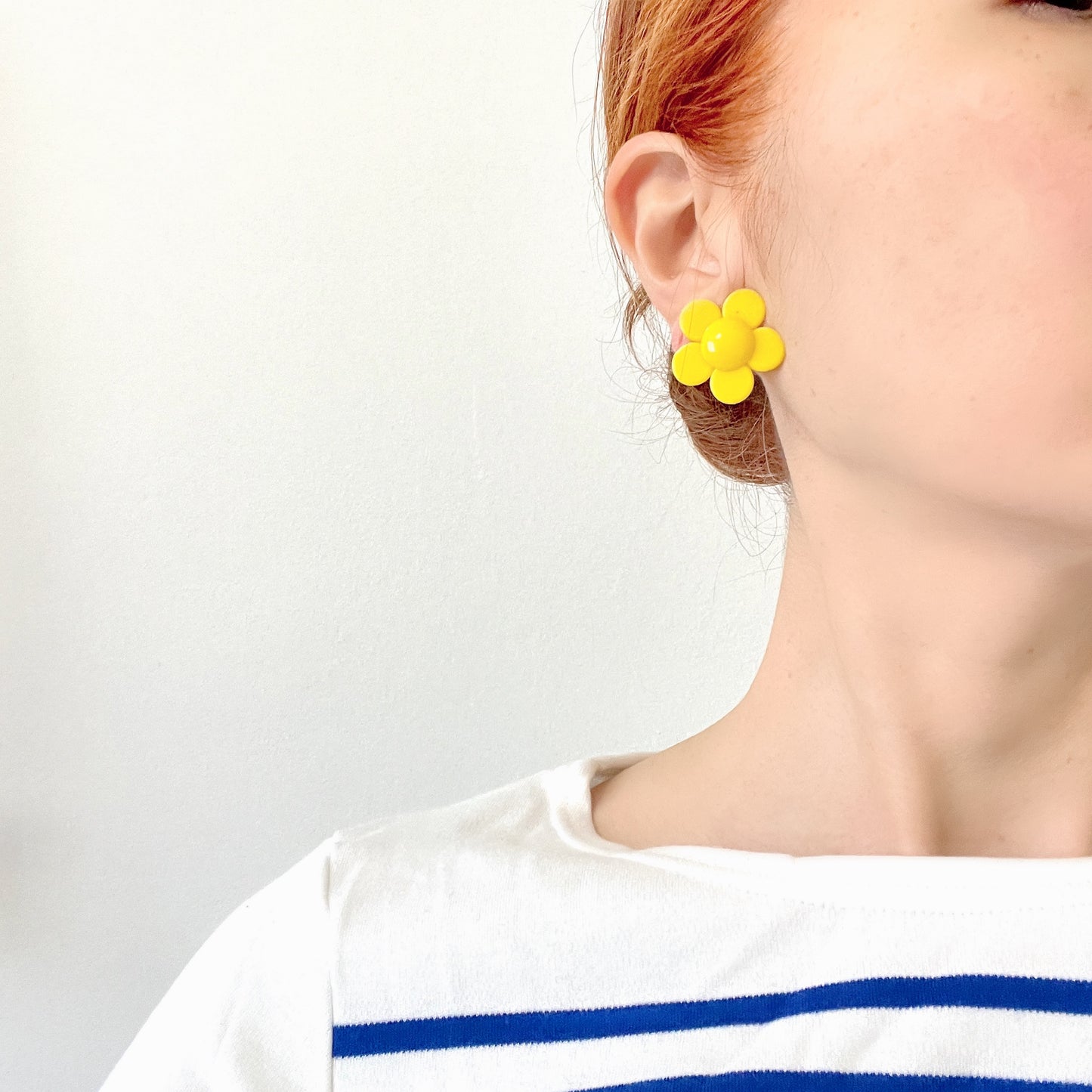 Flower clip-on earrings in a vivid buttery yellow tone. バターのようなビビッドイエローのお花のクリップイヤリング。