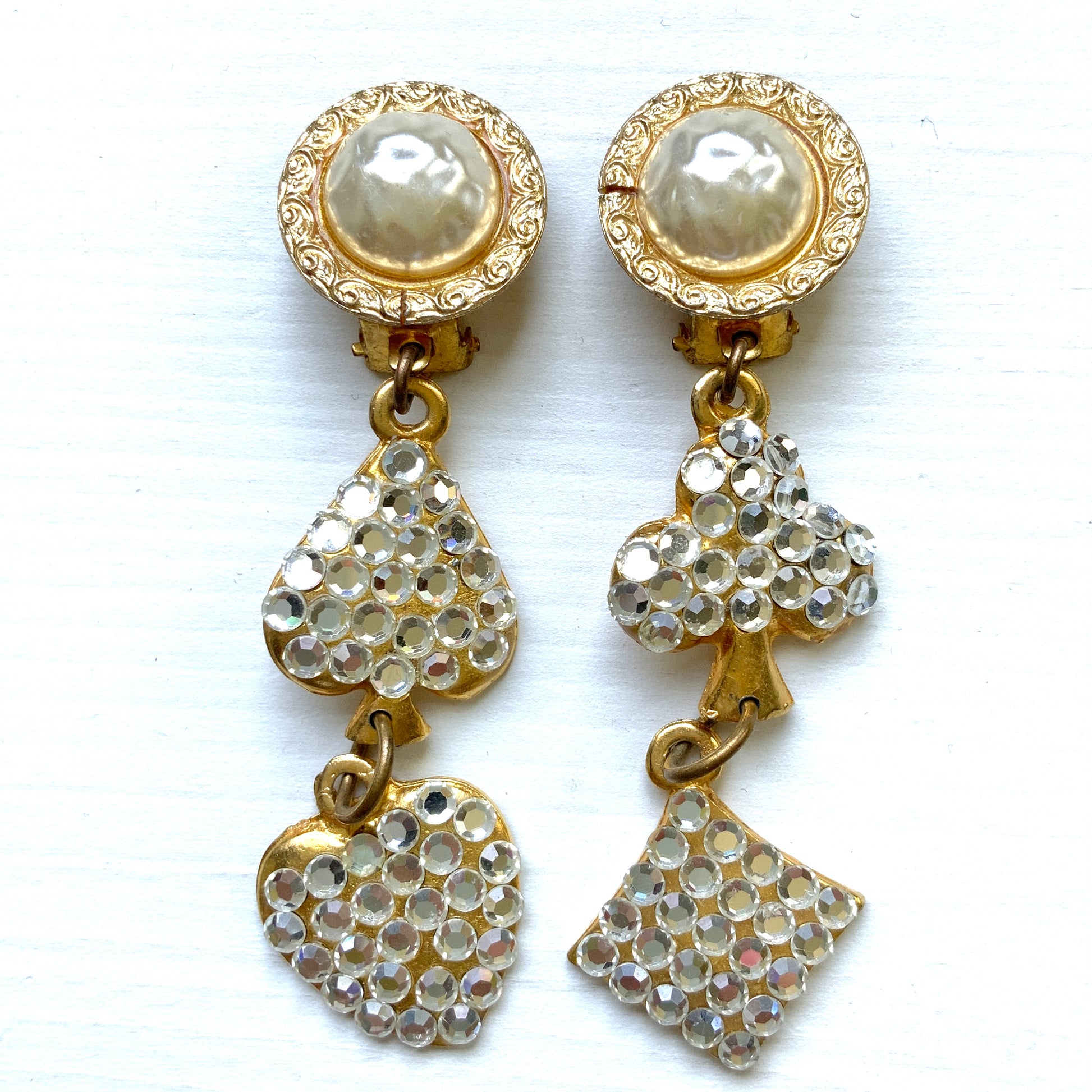 Clip-on Earrings with Pearl Cabochons and Dangling Playing Card Charms. パールカボションの下に、クリアラインストーンが散りばめられたトランプモチーフが揺れるクリップイヤリング。