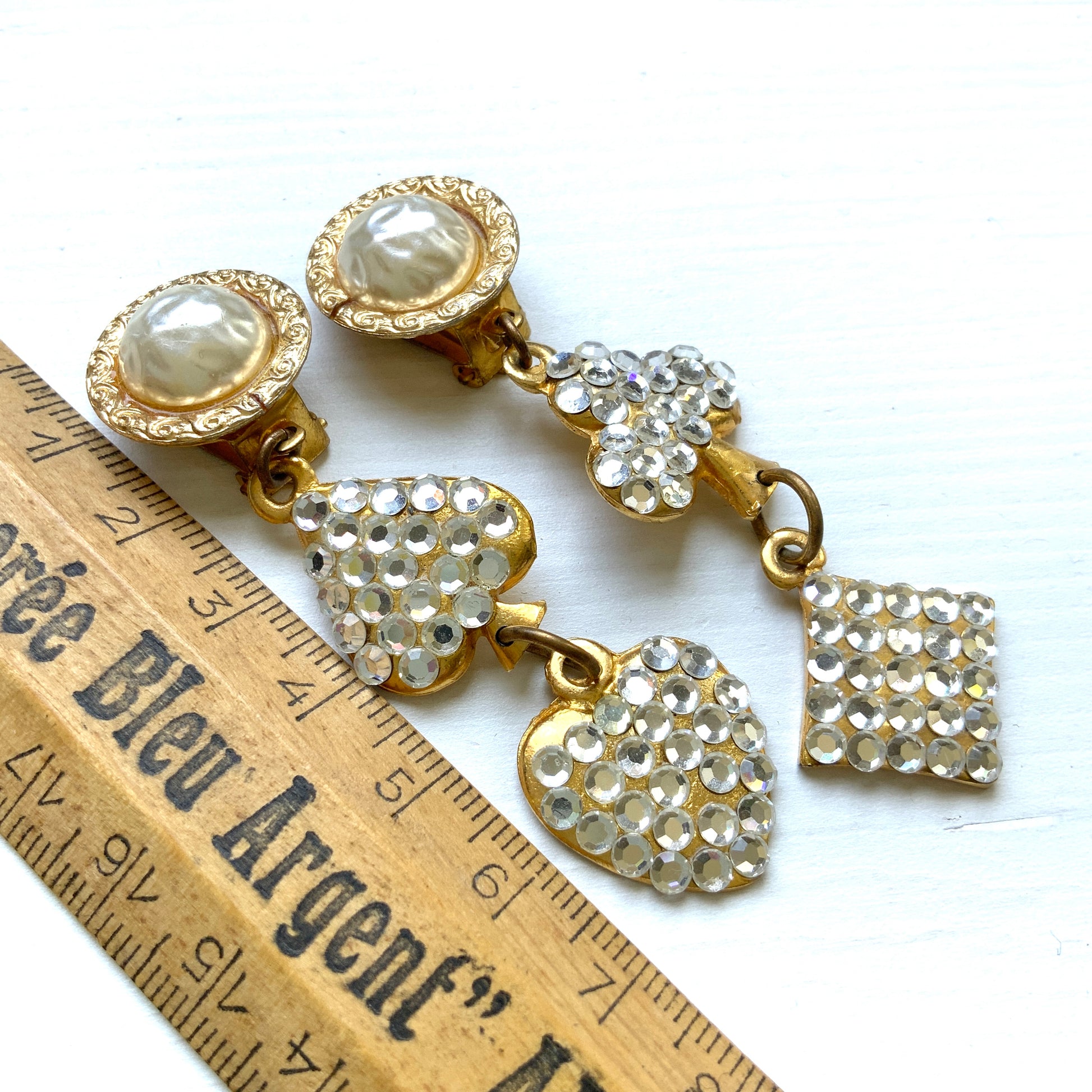Clip-on Earrings with Pearl Cabochons and Dangling Playing Card Charms. パールカボションの下に、クリアラインストーンが散りばめられたトランプモチーフが揺れるクリップイヤリング。