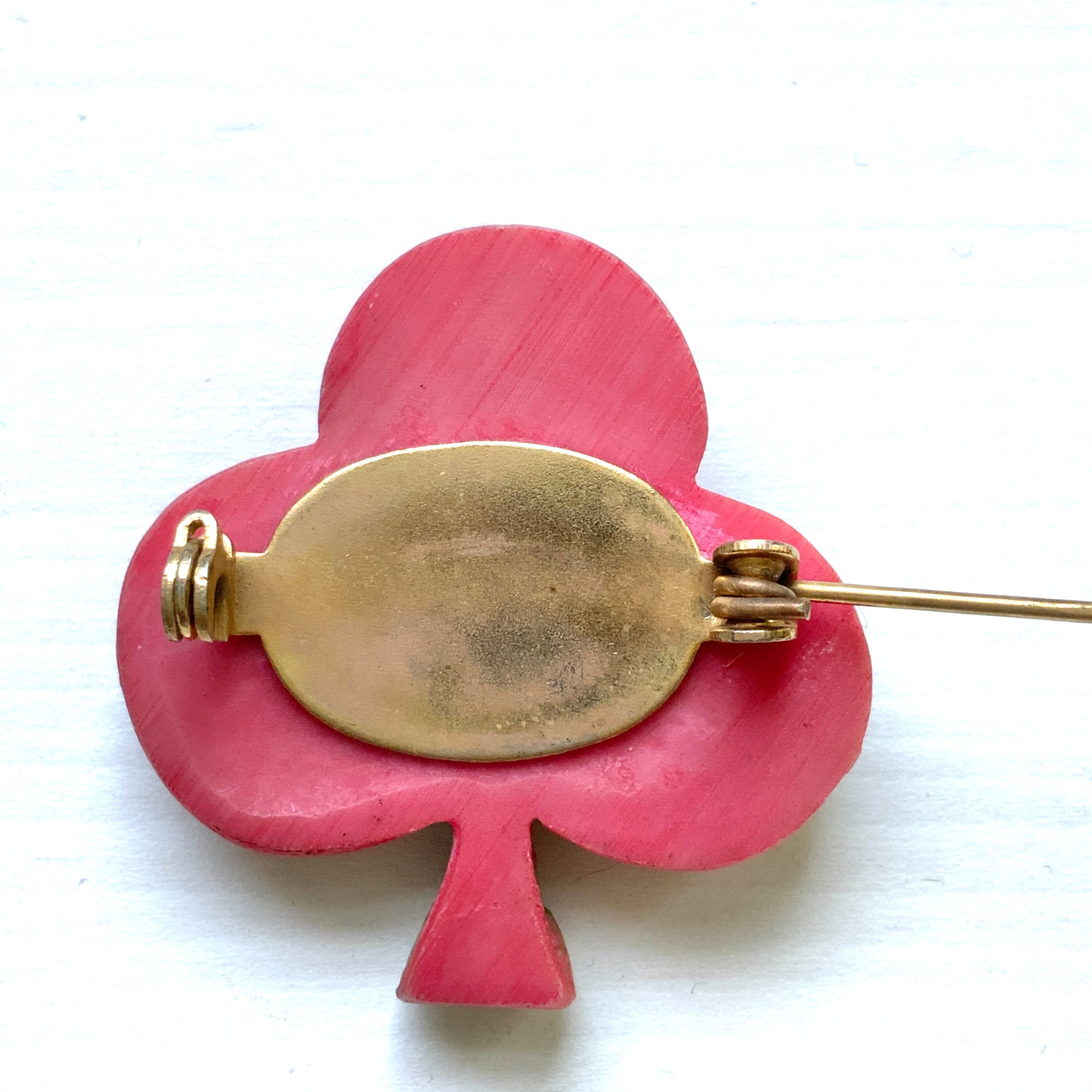 A brooch featuring a three-leaf clover motif, adorned with red roses and daisy flowers shaped into the design. 三つ葉クローバーのモチーフに、赤いバラやデイジーのお花が象られたブローチ。