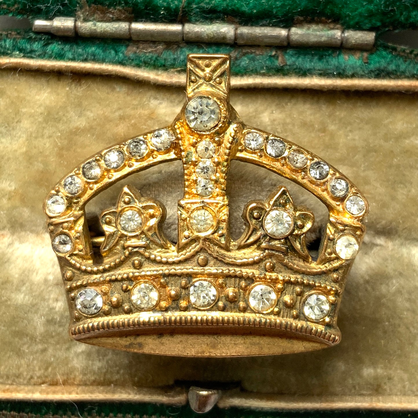 A gold-tone metal crown brooch adorned with clear rhinestones. ゴールドトーンメタルのクラウンに、クリアラインストーンがあしらわれたブローチ。