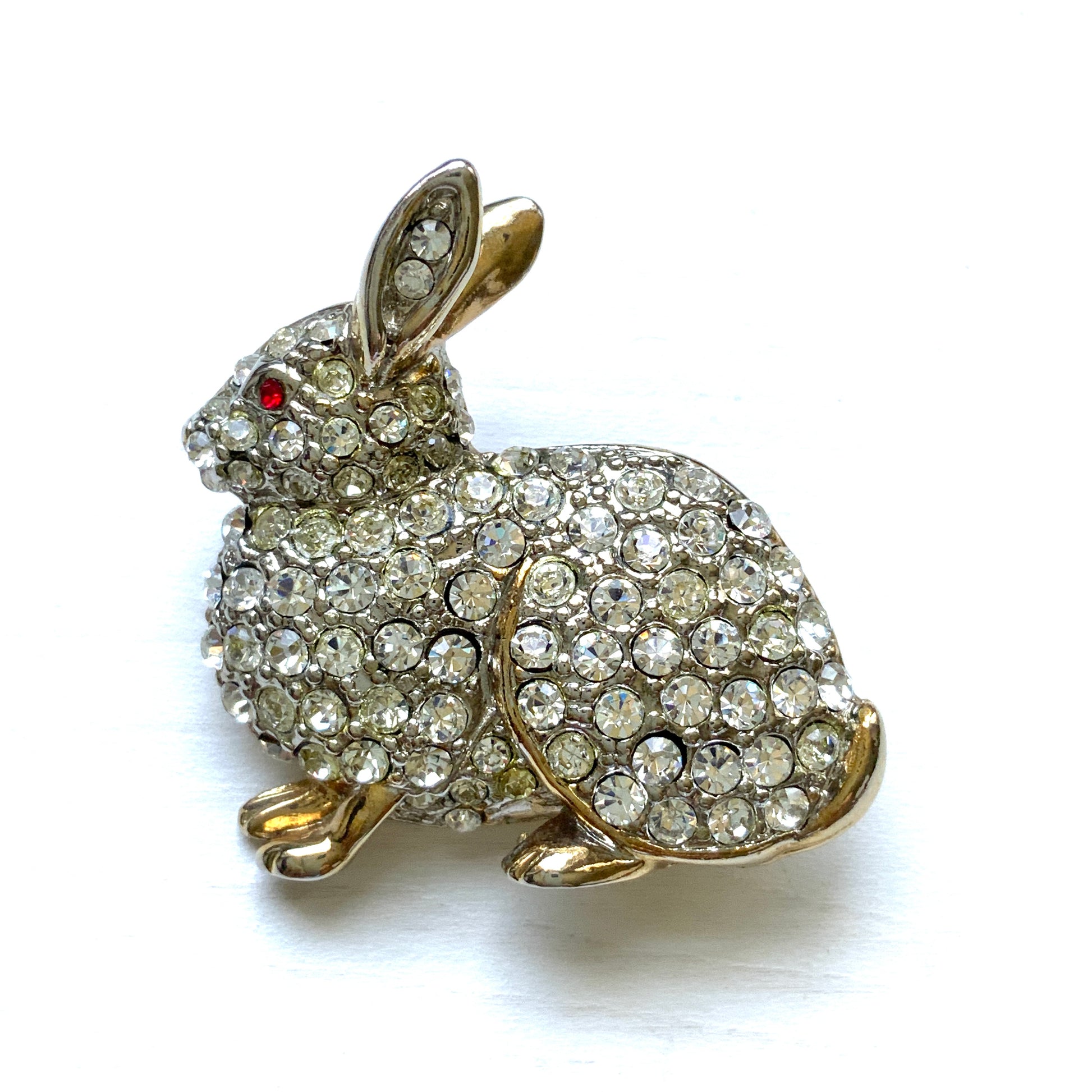A brooch featuring a rabbit with a plump body adorned with scattered clear rhinestones. ふっくらとしたボディにクリアラインストーンが散りばめられたうさぎのブローチ。
