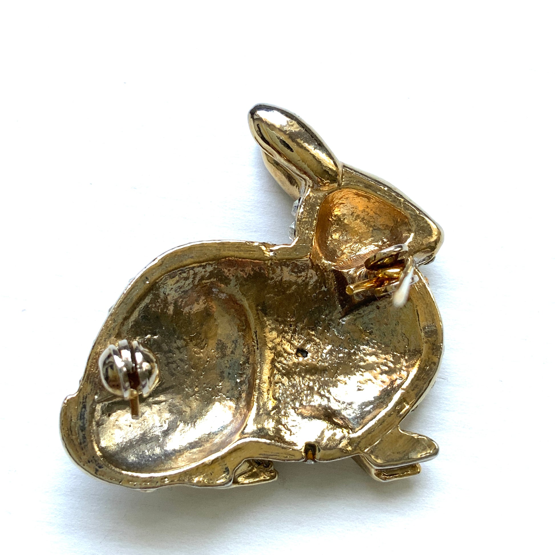 A brooch featuring a rabbit with a plump body adorned with scattered clear rhinestones. ふっくらとしたボディにクリアラインストーンが散りばめられたうさぎのブローチ。