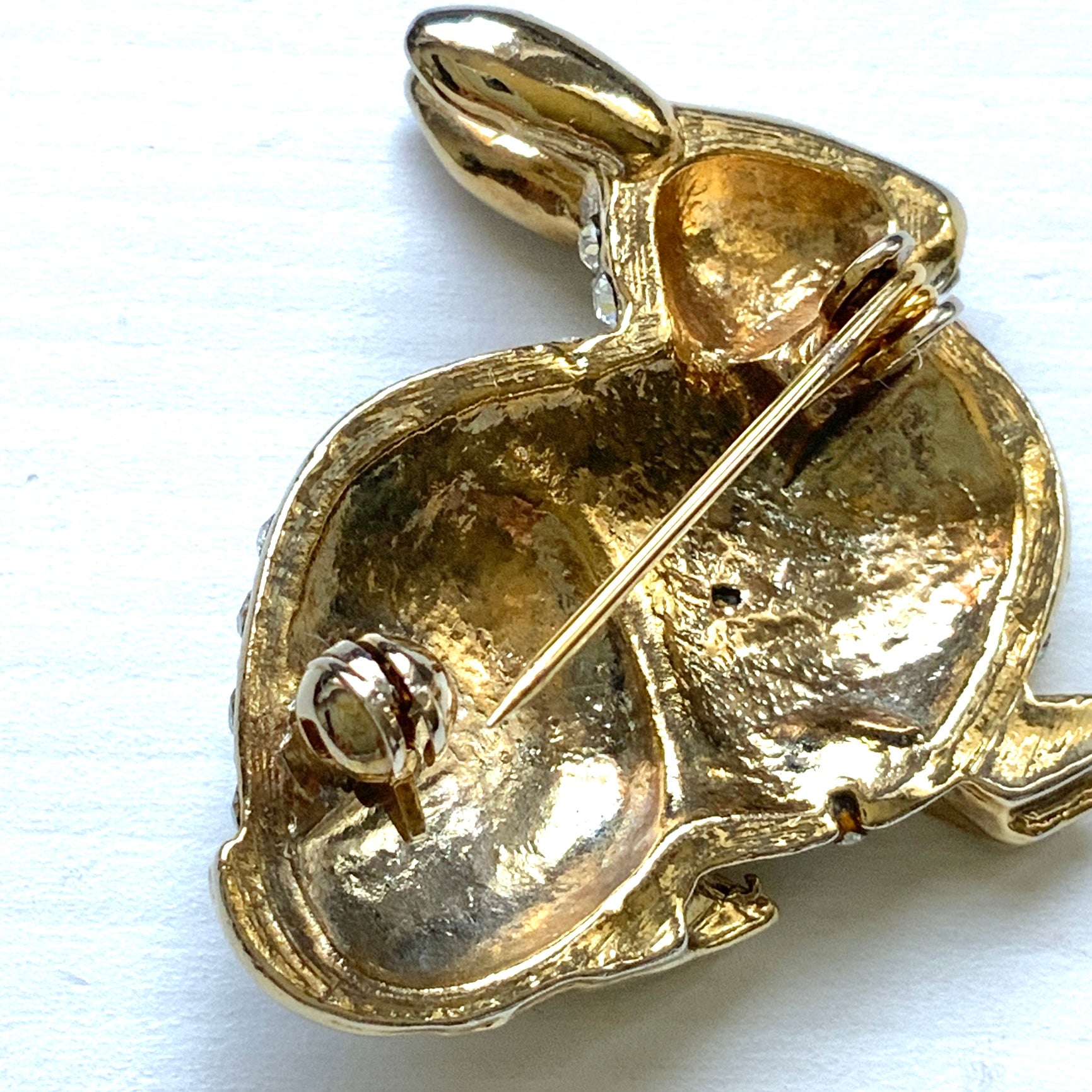 A brooch featuring a rabbit with a plump body adorned with scattered clear rhinestones. ふっくらとしたボディにクリアラインストーンが散りばめられたうさぎのブローチ。