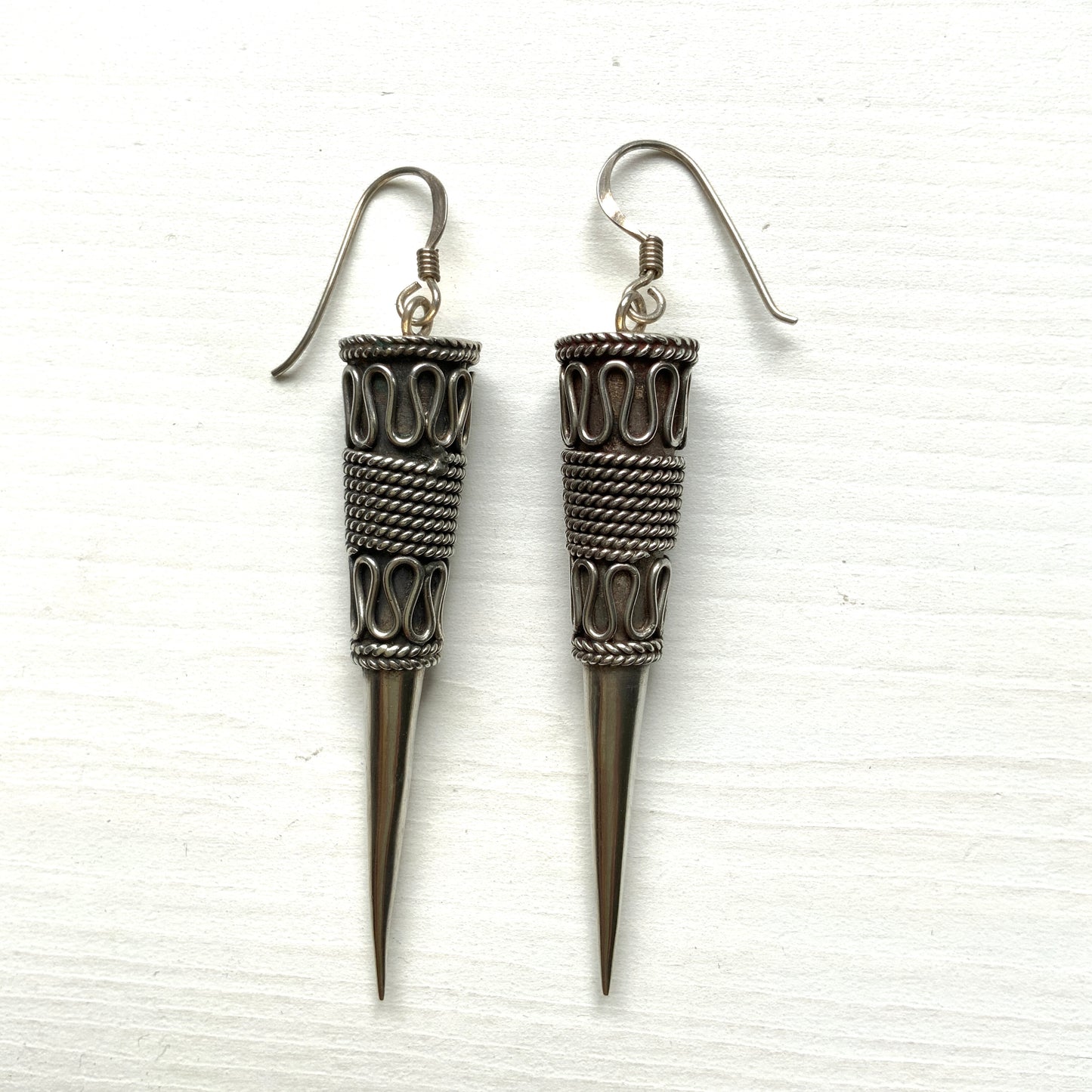 Silver spike-shaped earrings with tribal-inspired patterns. トライバルな模様が入った細長いスパイク型のシルバーピアス。