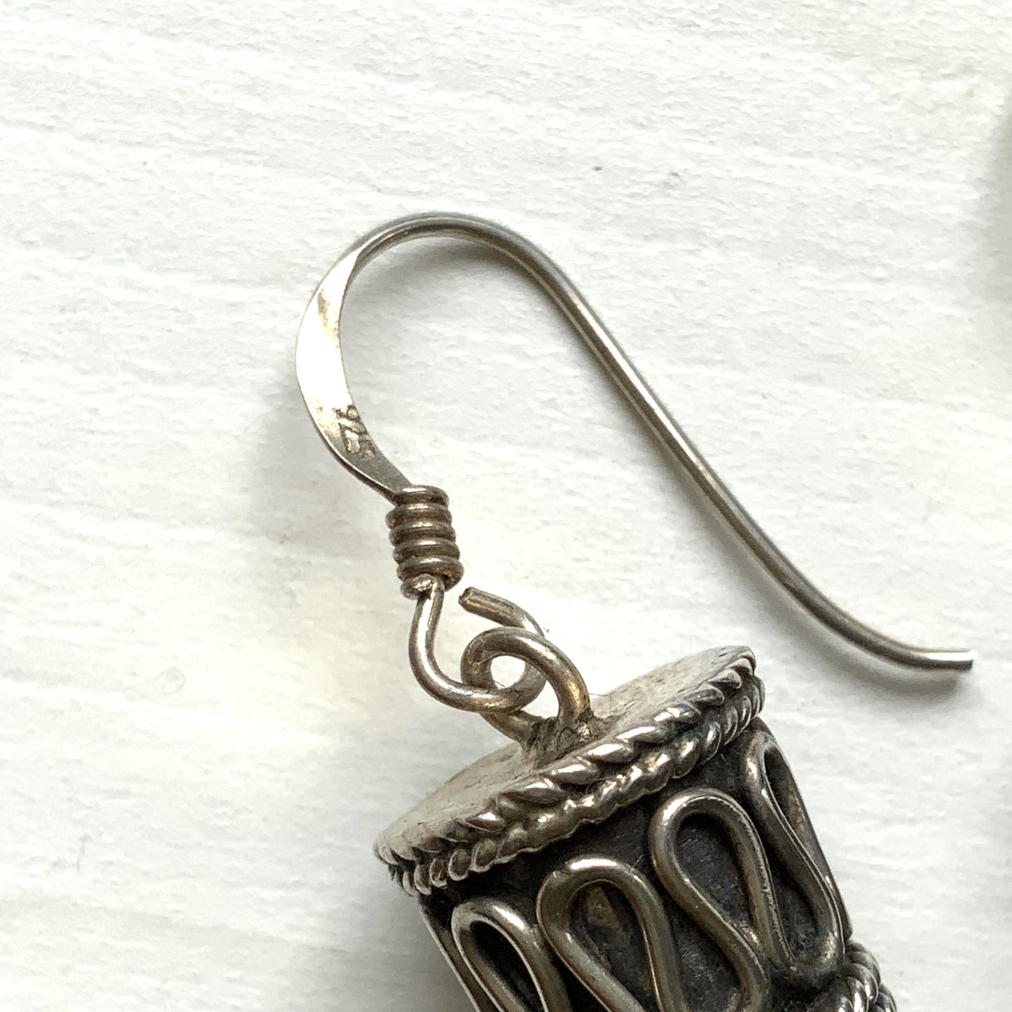 Silver spike-shaped earrings with tribal-inspired patterns. トライバルな模様が入った細長いスパイク型のシルバーピアス。