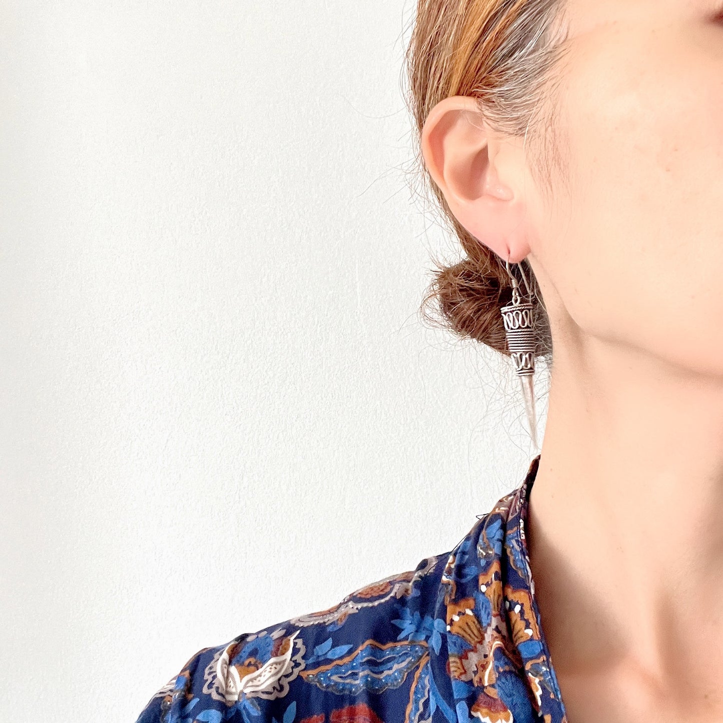 Silver spike-shaped earrings with tribal-inspired patterns. トライバルな模様が入った細長いスパイク型のシルバーピアス。