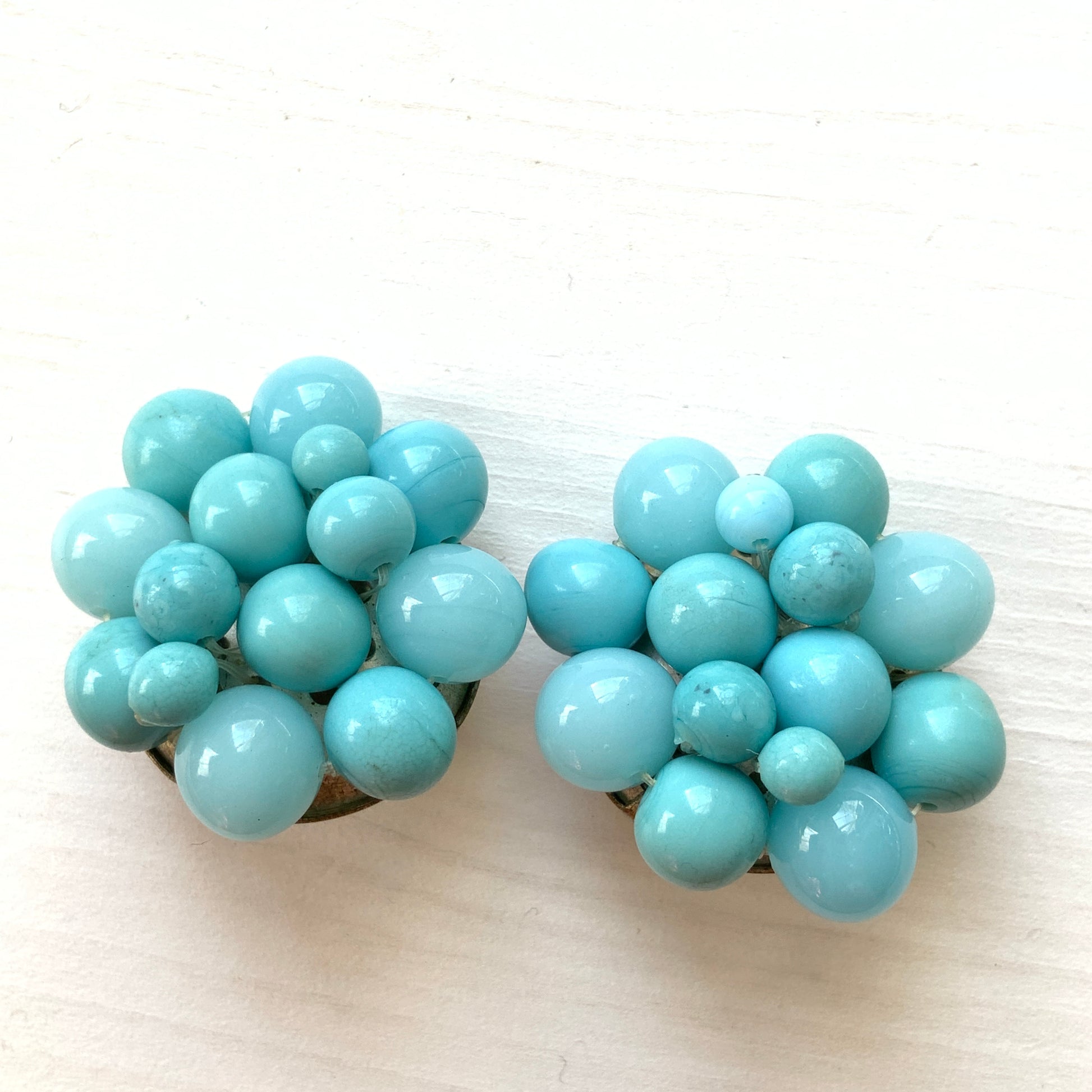 These clip-on earrings feature a charming cluster of turquoise-colored glass beads in various shapes and sizes. いろいろな大きさのターコイズカラーのグラスビーズが集まったクリップイヤリング。