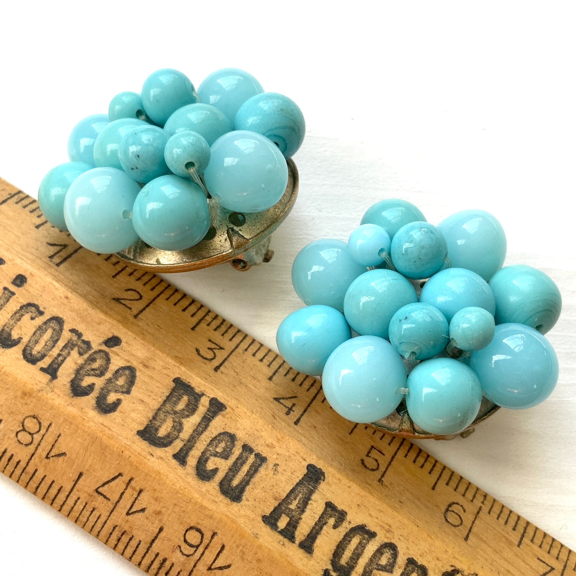 These clip-on earrings feature a charming cluster of turquoise-colored glass beads in various shapes and sizes. いろいろな大きさのターコイズカラーのグラスビーズが集まったクリップイヤリング。