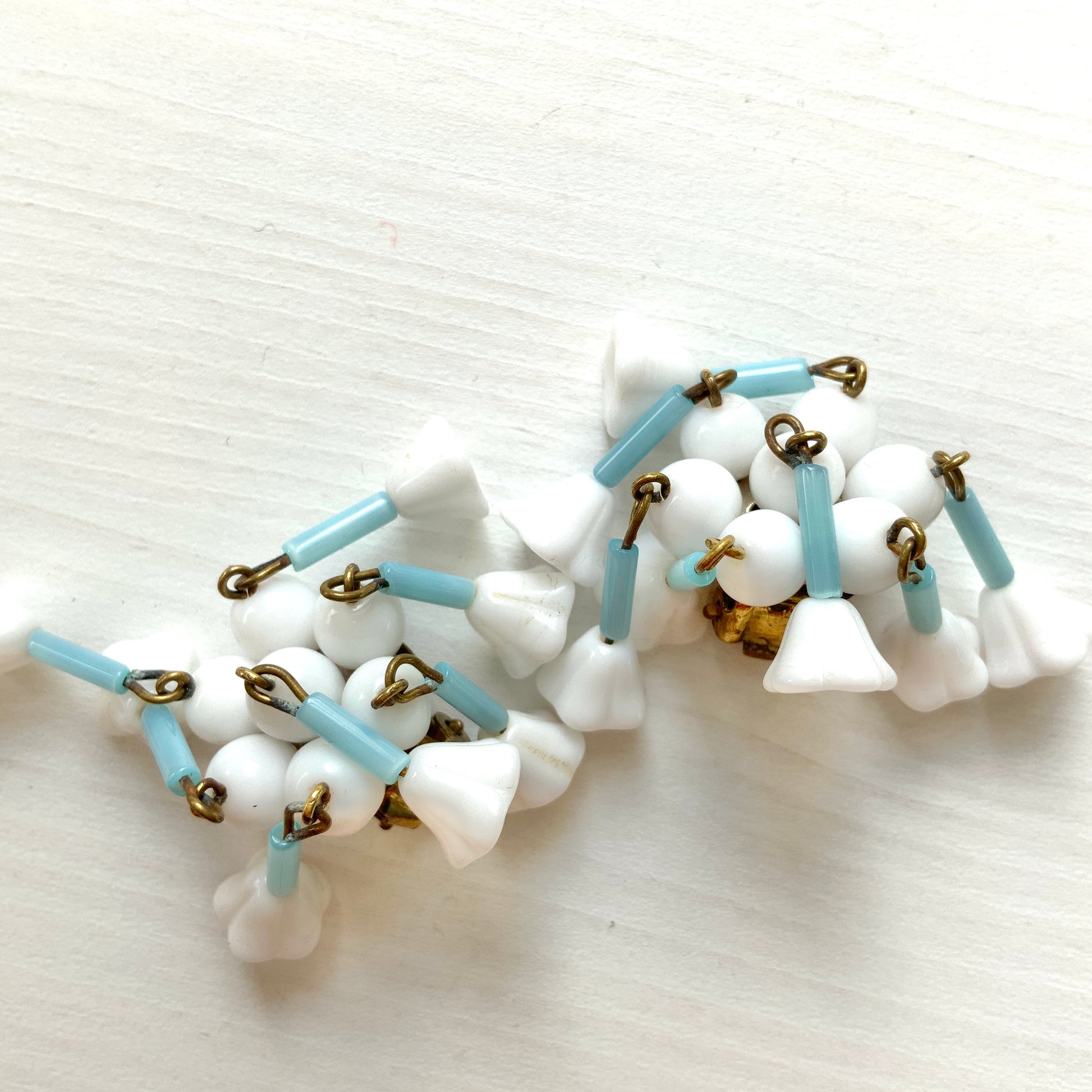 These clip-on earrings feature a waterfall design with white glass flower beads that gently dangle. 白いお花のグラスビーズがゆれるウォーターフォールスタイルのクリップイヤリング。