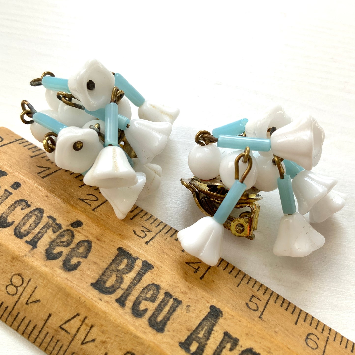 These clip-on earrings feature a waterfall design with white glass flower beads that gently dangle. 白いお花のグラスビーズがゆれるウォーターフォールスタイルのクリップイヤリング。