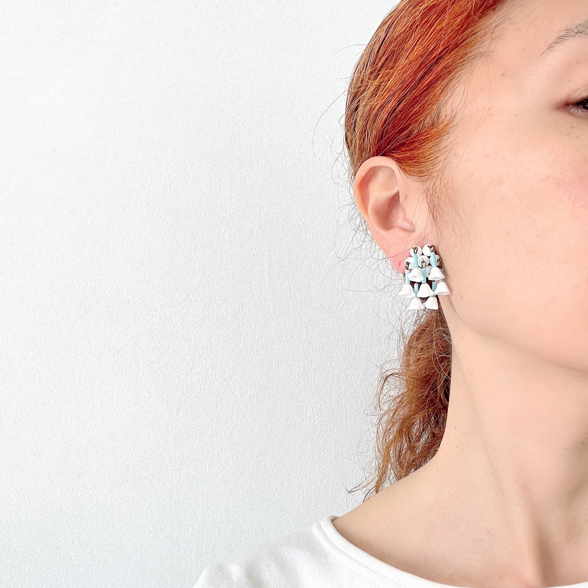 These clip-on earrings feature a waterfall design with white glass flower beads that gently dangle. 白いお花のグラスビーズがゆれるウォーターフォールスタイルのクリップイヤリング。