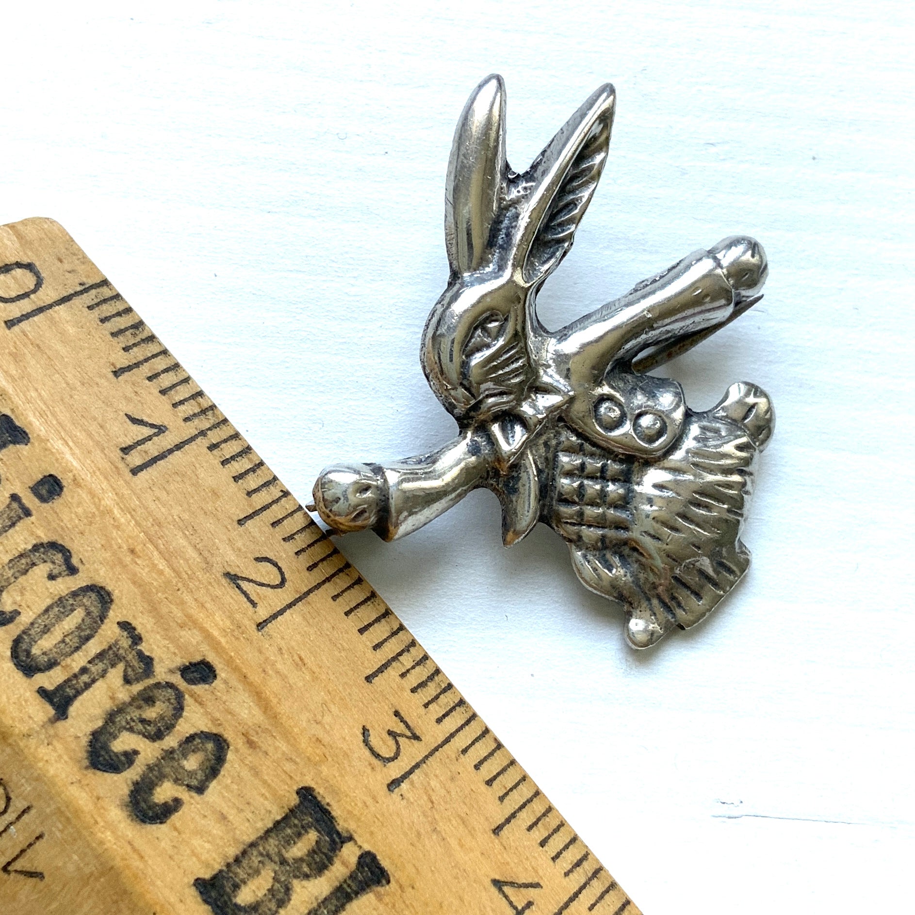 This silver brooch features a rabbit dressed in a waistcoat and jacket. ベストとジャケットを着たうさぎのシルバーブローチ。
