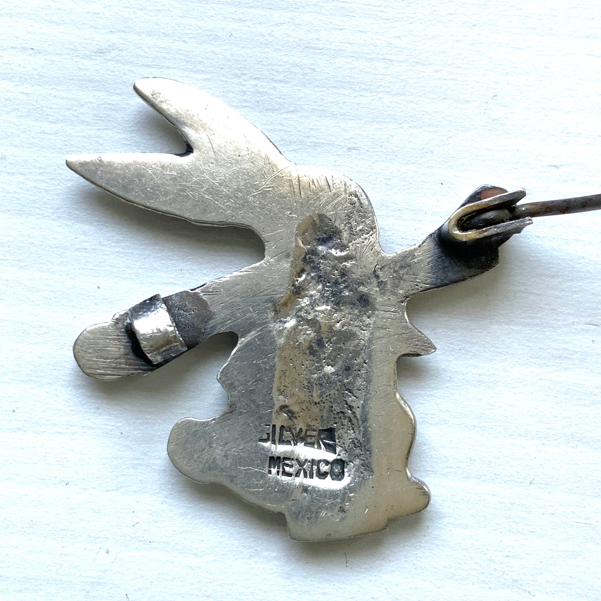 This silver brooch features a rabbit dressed in a waistcoat and jacket. ベストとジャケットを着たうさぎのシルバーブローチ。