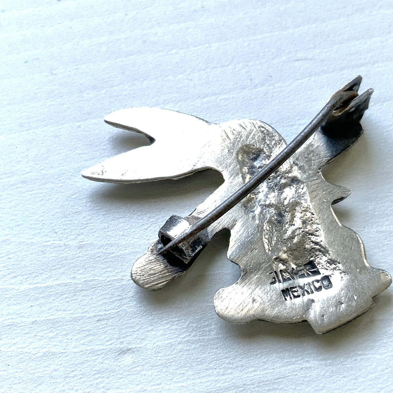 This silver brooch features a rabbit dressed in a waistcoat and jacket. ベストとジャケットを着たうさぎのシルバーブローチ。