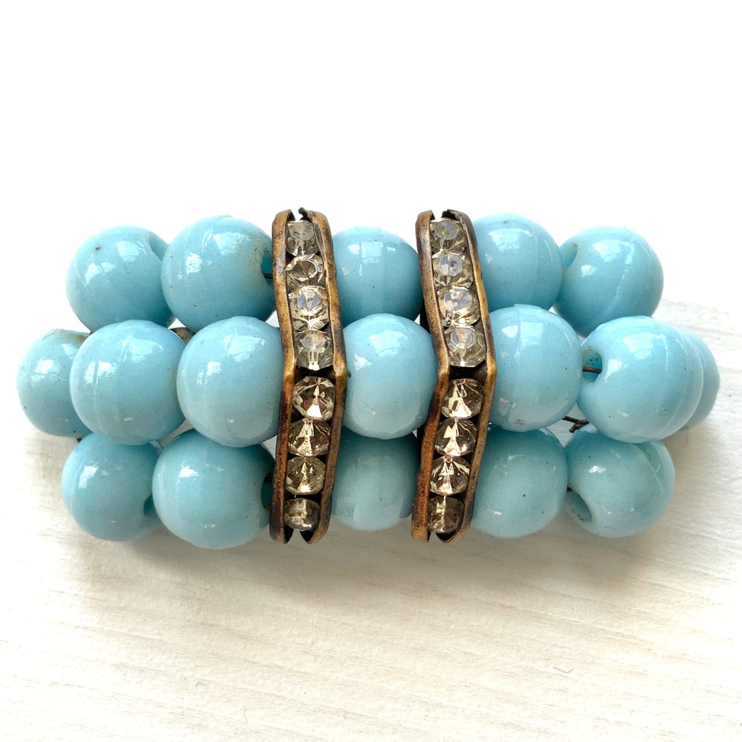 A brooch featuring baby blue glass ball beads arranged in a rectangular pattern.  ベビーブルーのグラスボールビーズが長方形に並んだブローチ。