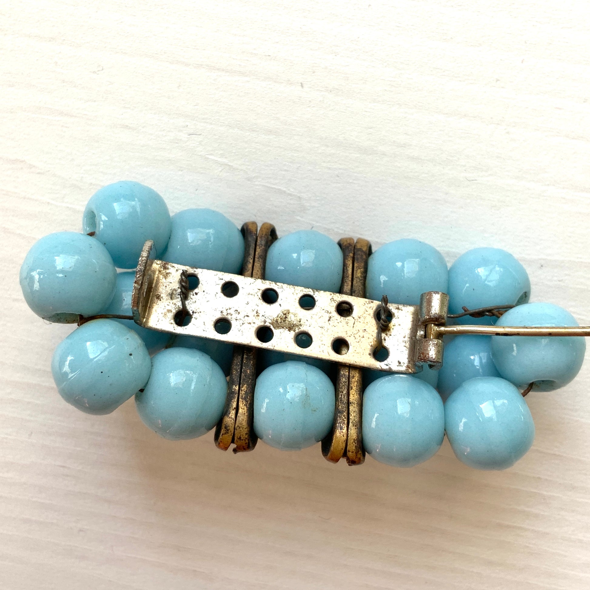 A brooch featuring baby blue glass ball beads arranged in a rectangular pattern.  ベビーブルーのグラスボールビーズが長方形に並んだブローチ。
