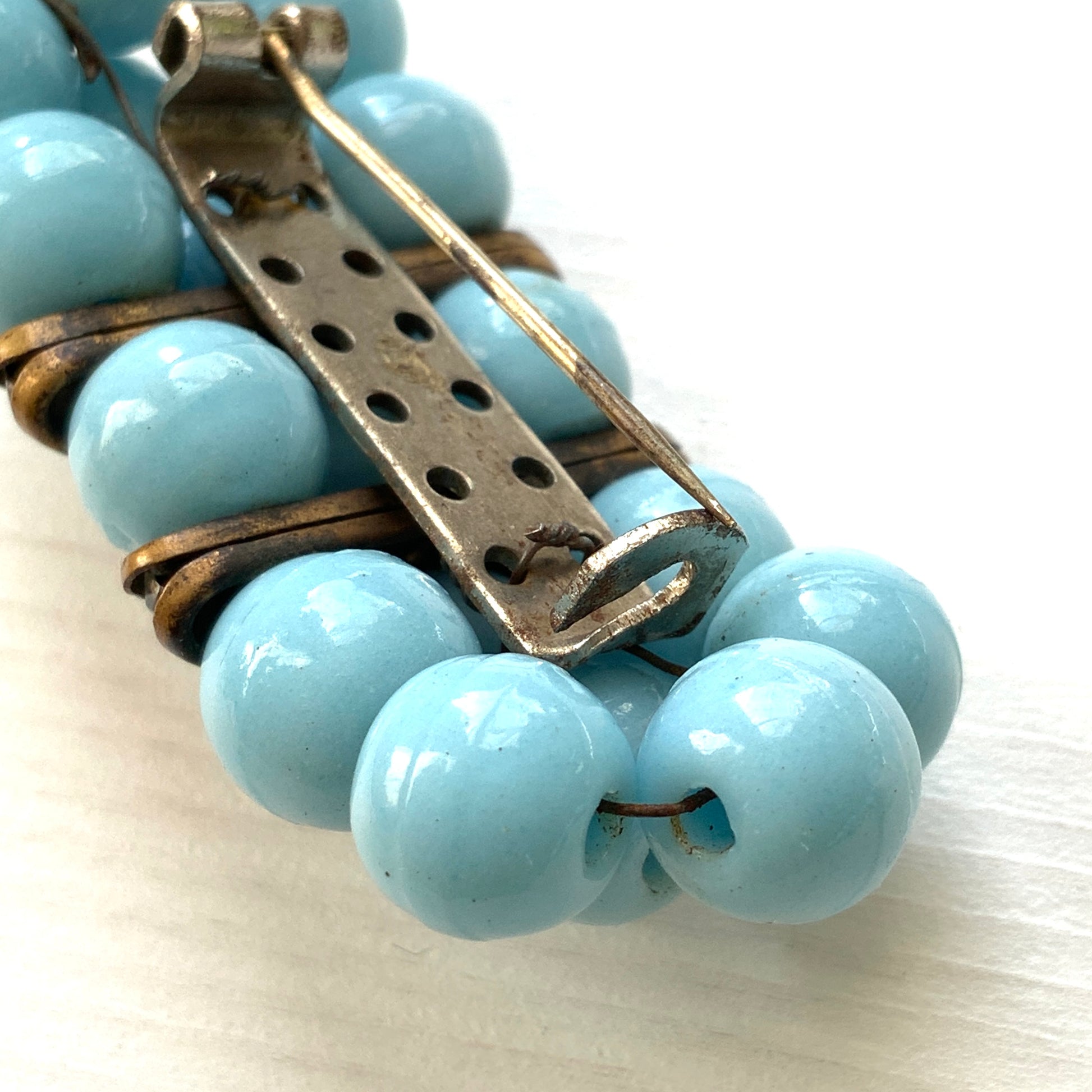 A brooch featuring baby blue glass ball beads arranged in a rectangular pattern.  ベビーブルーのグラスボールビーズが長方形に並んだブローチ。
