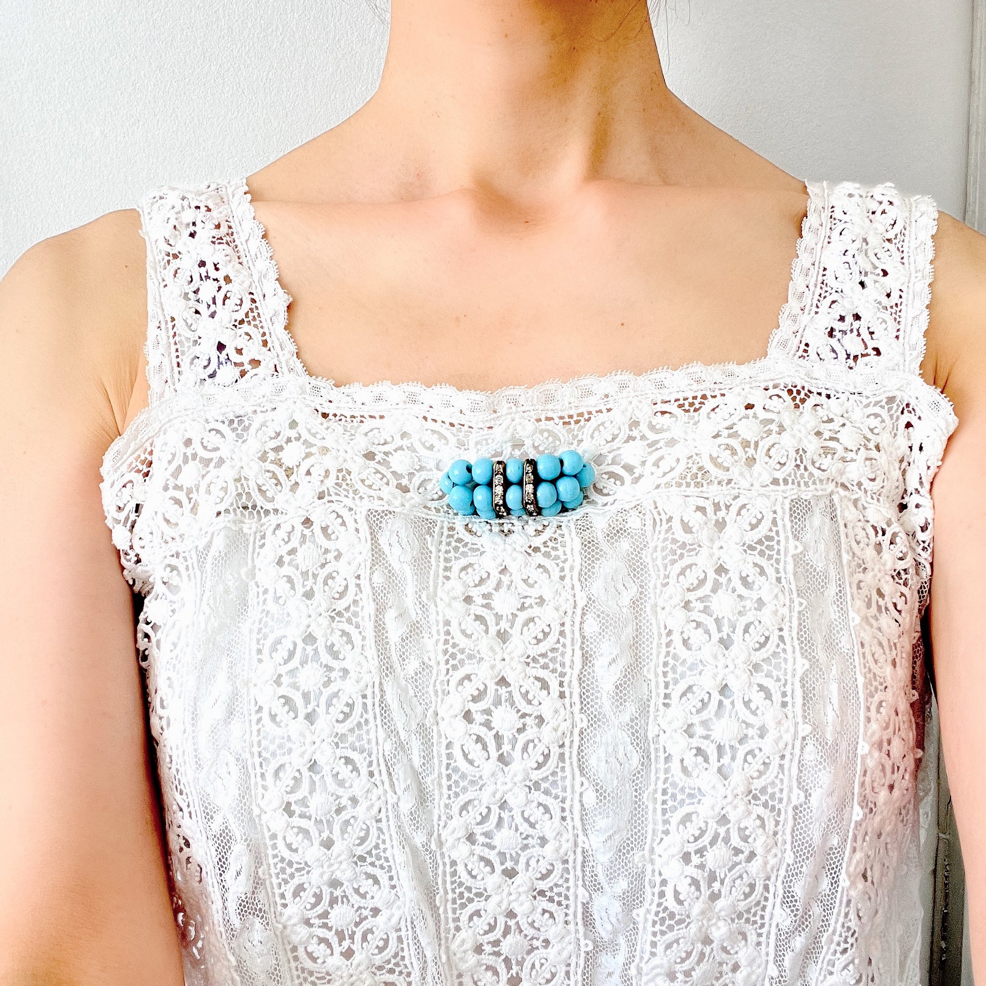 A brooch featuring baby blue glass ball beads arranged in a rectangular pattern.  ベビーブルーのグラスボールビーズが長方形に並んだブローチ。