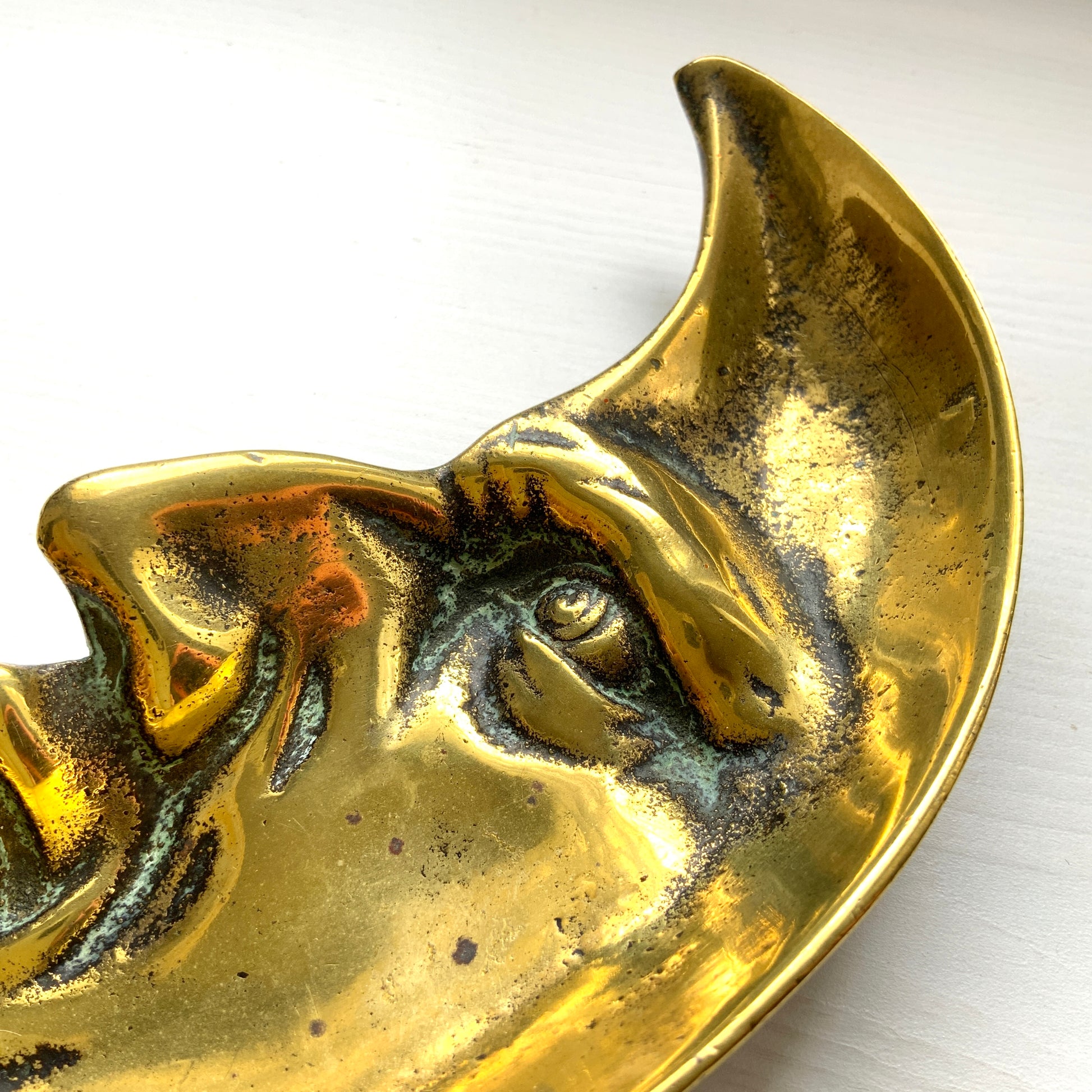 A vintage brass crescent moon ashtray featuring a serene expression. 穏やかな表情を浮かべた三日月が印象的なヴィンテージの真鍮製アッシュトレイ。