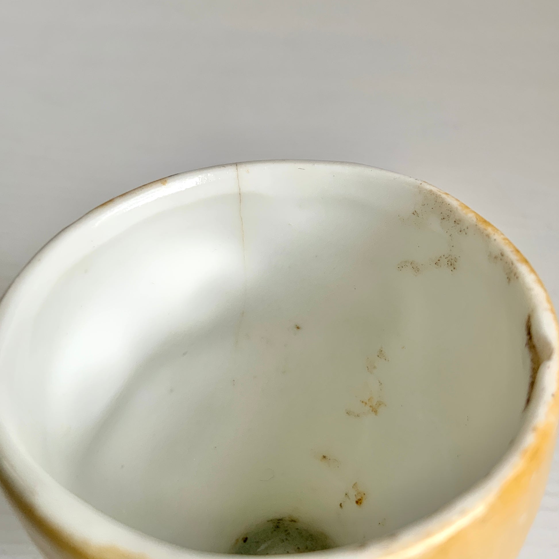A charming vintage egg cup featuring a smiling child with blue eyes and blonde hair. ブルーアイズとブロンドヘアが印象的な、愛らしい笑顔を浮かべた子どもの顔のヴィンテージエッグカップ。 
