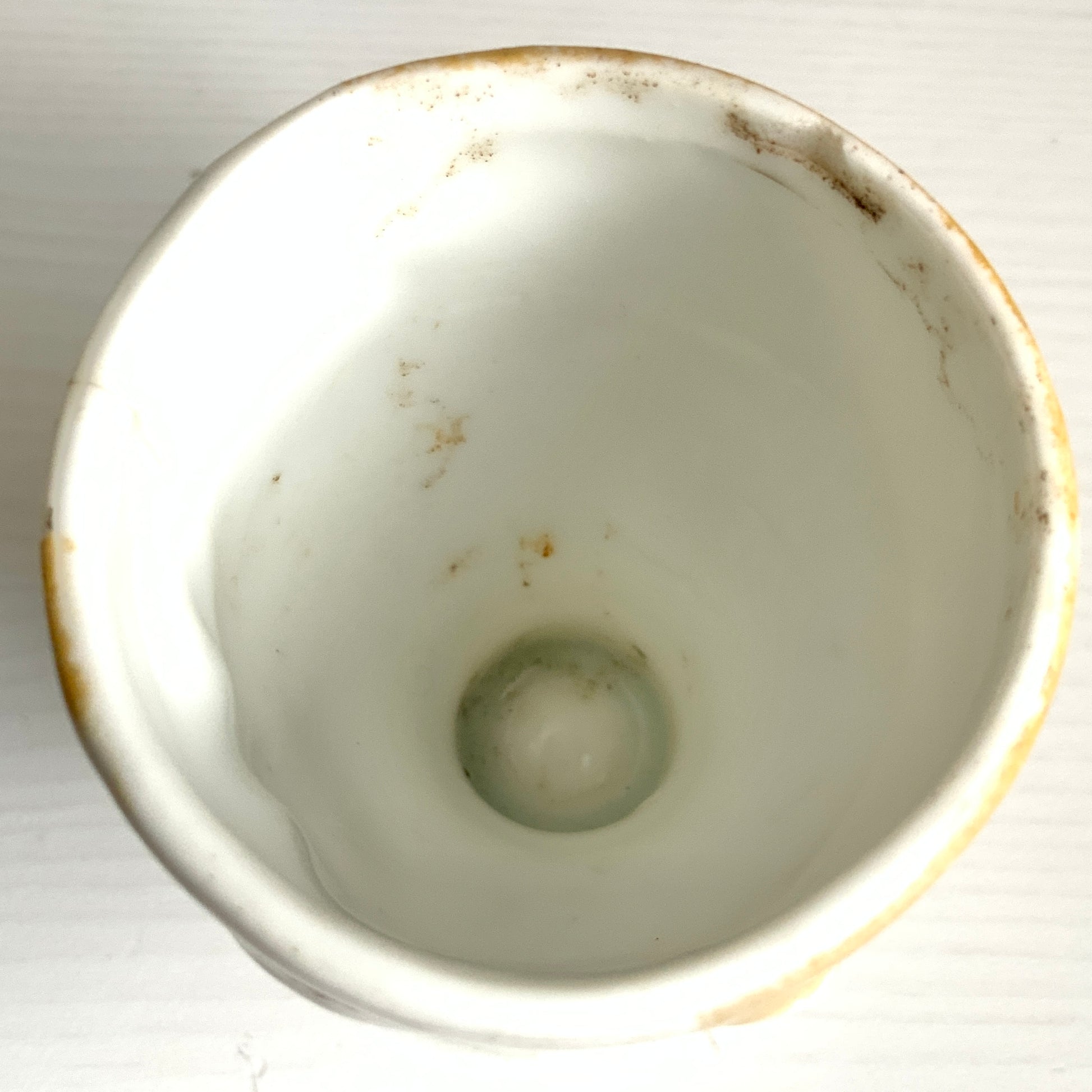 A charming vintage egg cup featuring a smiling child with blue eyes and blonde hair. ブルーアイズとブロンドヘアが印象的な、愛らしい笑顔を浮かべた子どもの顔のヴィンテージエッグカップ。 