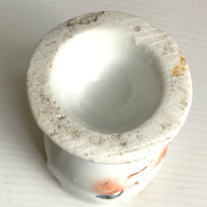 A charming vintage egg cup featuring a smiling child with blue eyes and blonde hair. ブルーアイズとブロンドヘアが印象的な、愛らしい笑顔を浮かべた子どもの顔のヴィンテージエッグカップ。 