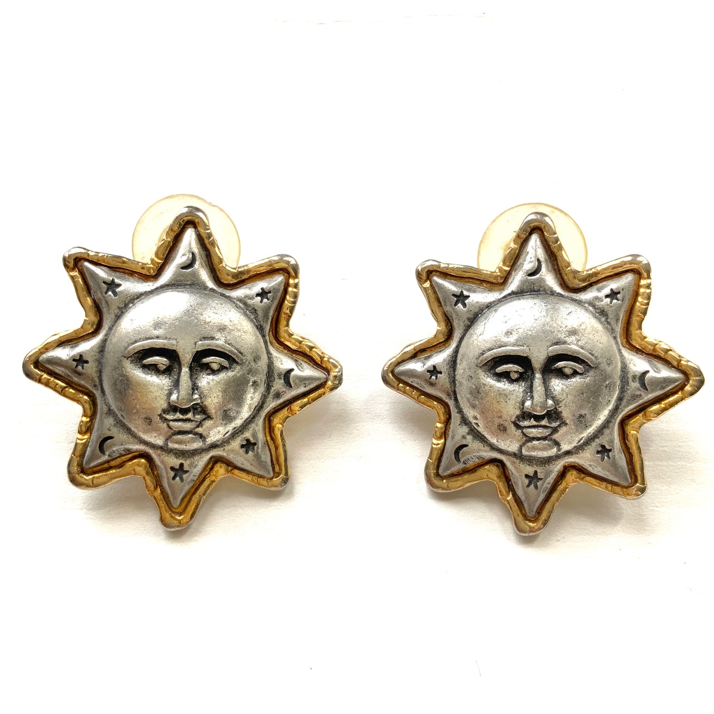 A charming pair of JJ sun earrings featuring a gentle smiling face.  穏やかな微笑みをたたえた、JJの太陽ピアス。 