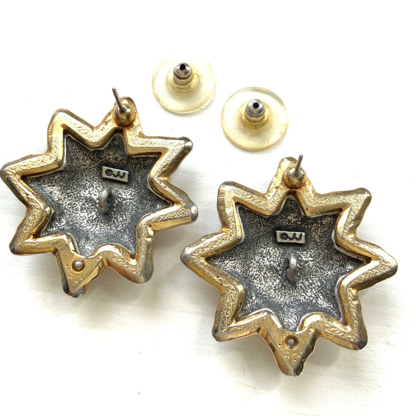 A charming pair of JJ sun earrings featuring a gentle smiling face.  穏やかな微笑みをたたえた、JJの太陽ピアス。 