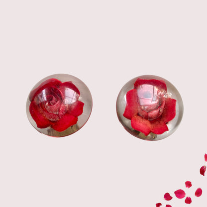 A beautiful pair of 1950s clip-on earrings featuring vivid red roses reverse carved into clear Lucite.  1950年代の赤いバラのインタリオのヴィンテージクリップイヤリング。