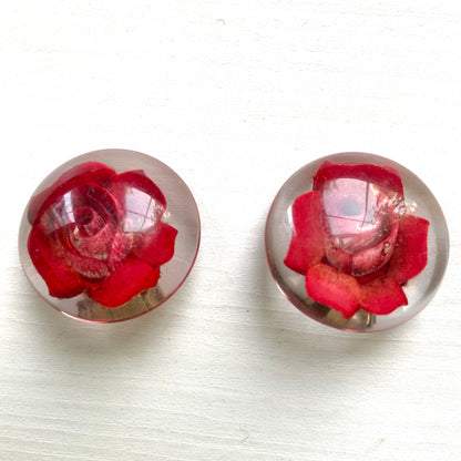 A beautiful pair of 1950s clip-on earrings featuring vivid red roses reverse carved into clear Lucite.  1950年代の赤いバラのインタリオのヴィンテージクリップイヤリング。