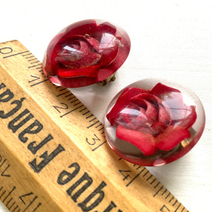 A beautiful pair of 1950s clip-on earrings featuring vivid red roses reverse carved into clear Lucite.  1950年代の赤いバラのインタリオのヴィンテージクリップイヤリング。