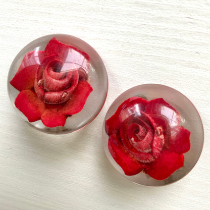 A beautiful pair of 1950s clip-on earrings featuring vivid red roses reverse carved into clear Lucite.  1950年代の赤いバラのインタリオのヴィンテージクリップイヤリング。