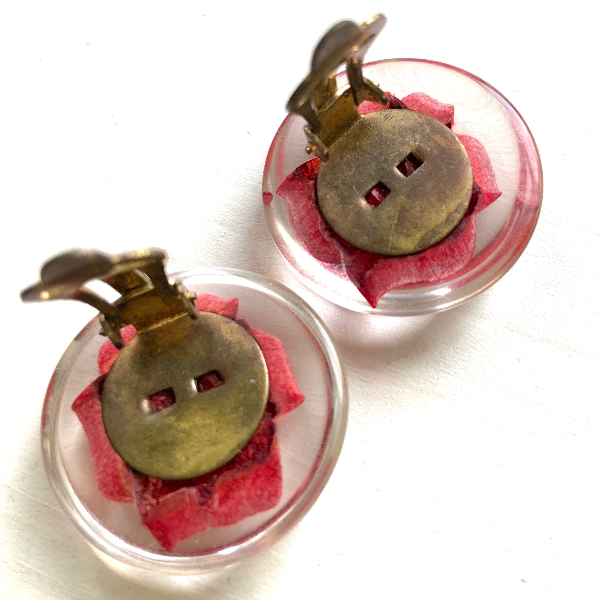 A beautiful pair of 1950s clip-on earrings featuring vivid red roses reverse carved into clear Lucite.  1950年代の赤いバラのインタリオのヴィンテージクリップイヤリング。