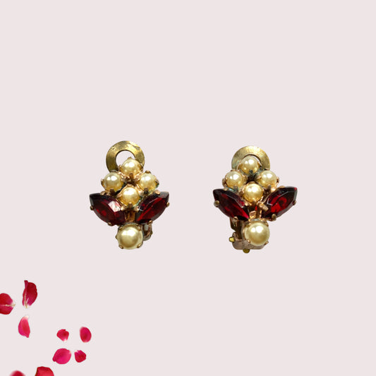 A charming pair of 1950s vintage clip-on earrings featuring deep ruby-red marquise-cut rhinestones and lustrous faux pearls in a classic floral design.  1950年代のフェイクパールとレッドラインストーンのヴィンテージクリップイヤリング。 
