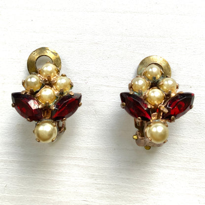 A charming pair of 1950s vintage clip-on earrings featuring deep ruby-red marquise-cut rhinestones and lustrous faux pearls in a classic floral design.  1950年代のフェイクパールとレッドラインストーンのヴィンテージクリップイヤリング。 