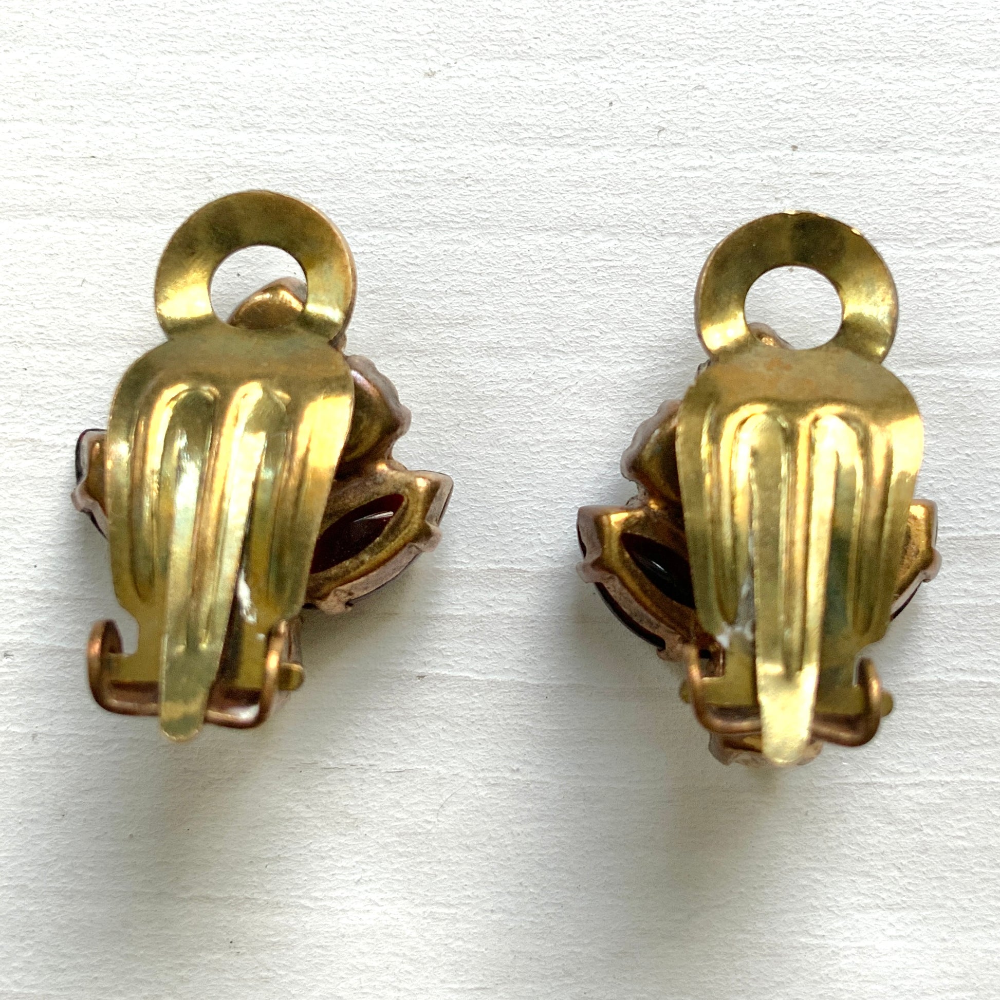 A charming pair of 1950s vintage clip-on earrings featuring deep ruby-red marquise-cut rhinestones and lustrous faux pearls in a classic floral design.  1950年代のフェイクパールとレッドラインストーンのヴィンテージクリップイヤリング。 