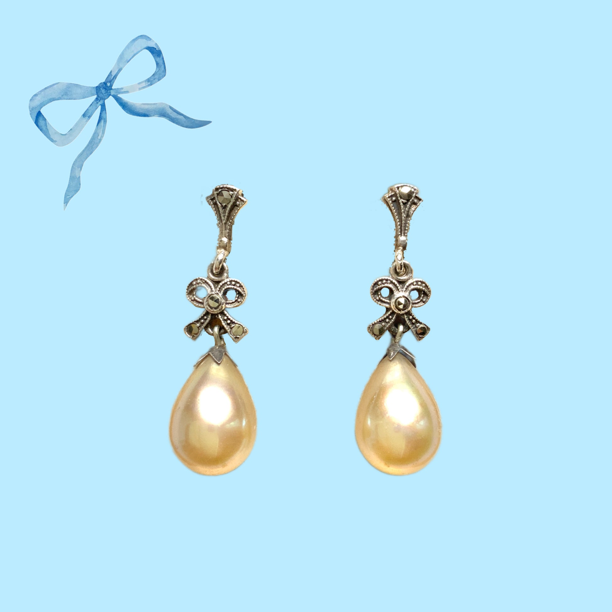 A pair of screw-back earrings featuring teardrop glass pearls suspended from silver bows. シルバー製のリボンに、ティアドロップのグラスパールが揺れるスクリューイヤリング。