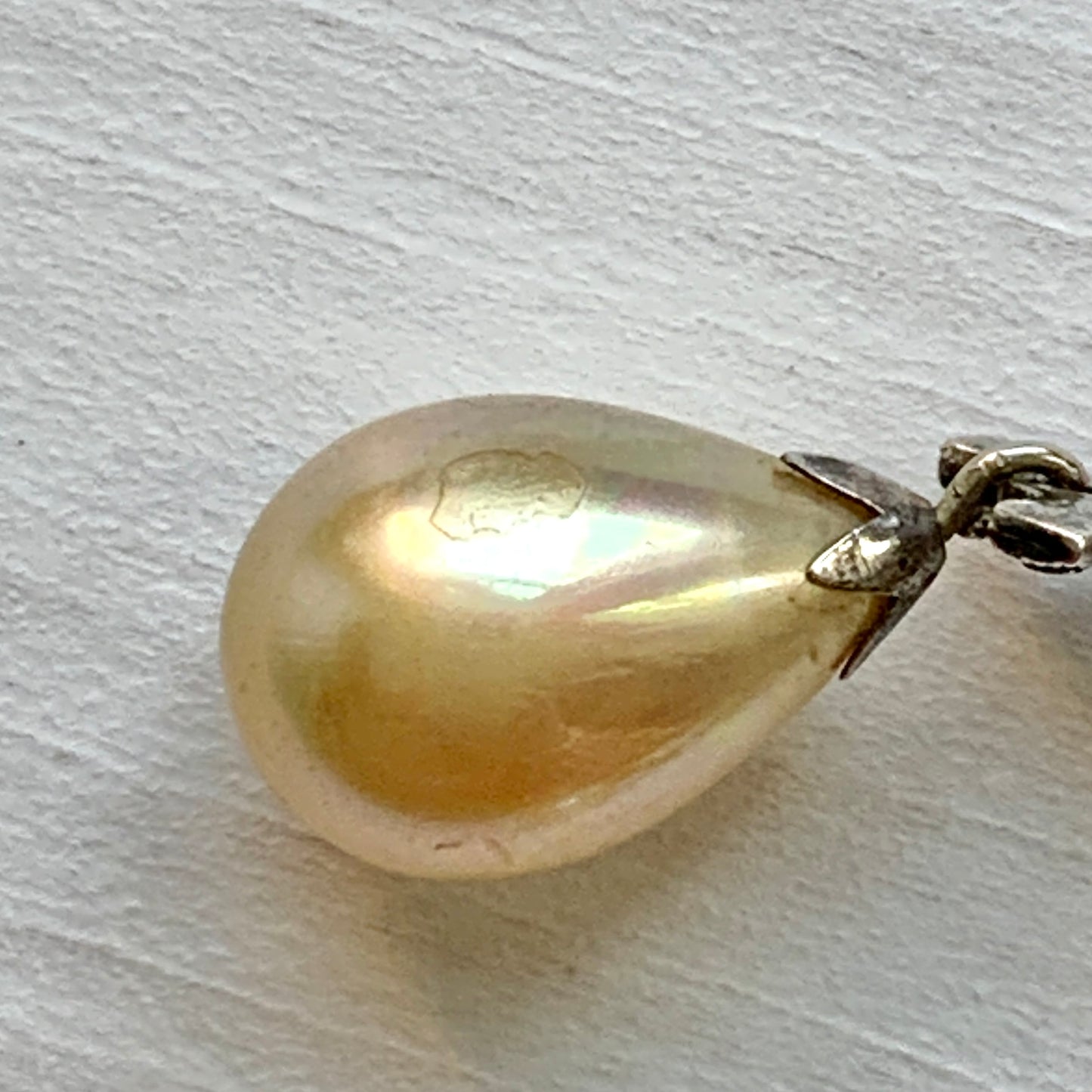 A pair of screw-back earrings featuring teardrop glass pearls suspended from silver bows. シルバー製のリボンに、ティアドロップのグラスパールが揺れるスクリューイヤリング。