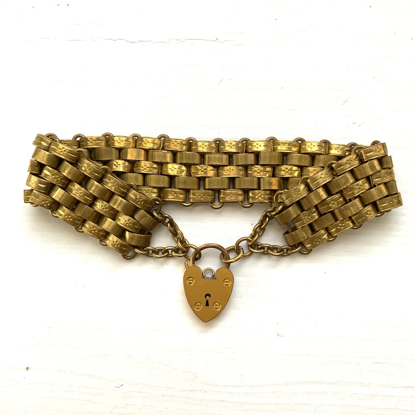 A bracelet featuring a heart-shaped padlock set on a heavy wide link chain. 重厚感のあるワイドリンクチェーンに、ハート型のパッドロックをあしらったブレスレット。